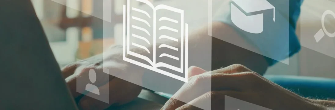 Una persona escribe en el teclado de un ordenador portátil, con iconos flotantes translúcidos en primer plano, como un libro abierto, un birrete de graduación y un trofeo, que representan el aprendizaje en línea o la educación digital. -corvt_ar
